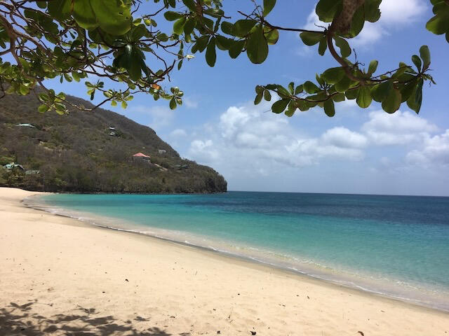 Lower Bay, Bequia view from the beach at Lower Bay, island of Bequia, St. Vincent and the Grenadines. A white sandy beach and turquoise blue water.