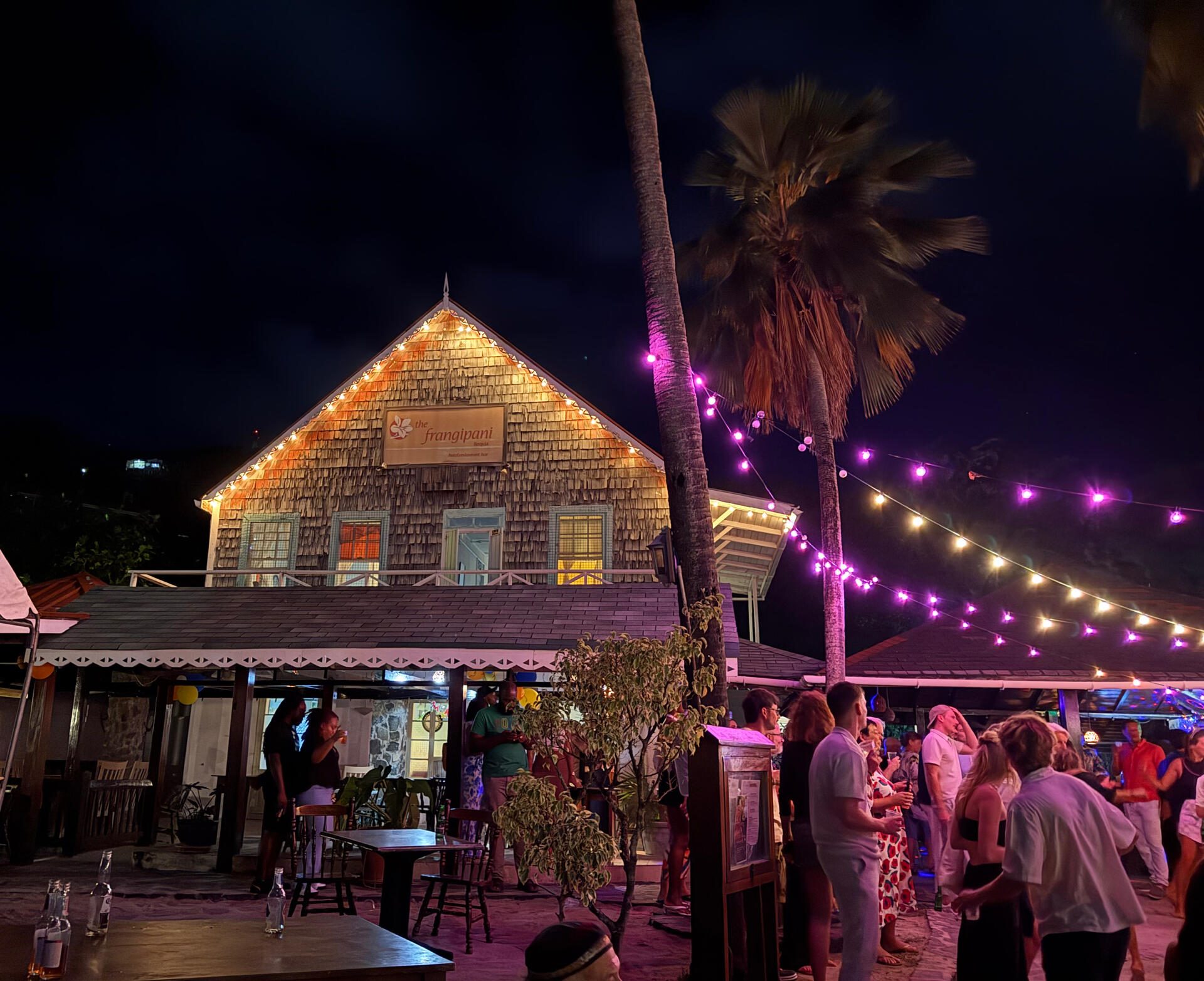 The Frangipani Nighttime party at the Frangipani with string lights and people dancing